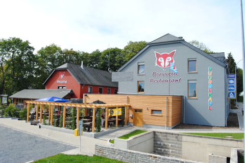 Camping Fuussekaul à Wiltz, Luxembourg, avec la Brasserie Restaurant et terrasse extérieure sous pergola.