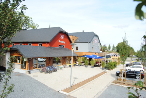 Photo of Camping Fuussekaul holiday park in Wiltz, Luxembourg, showing bikes, terrace, and parking area.