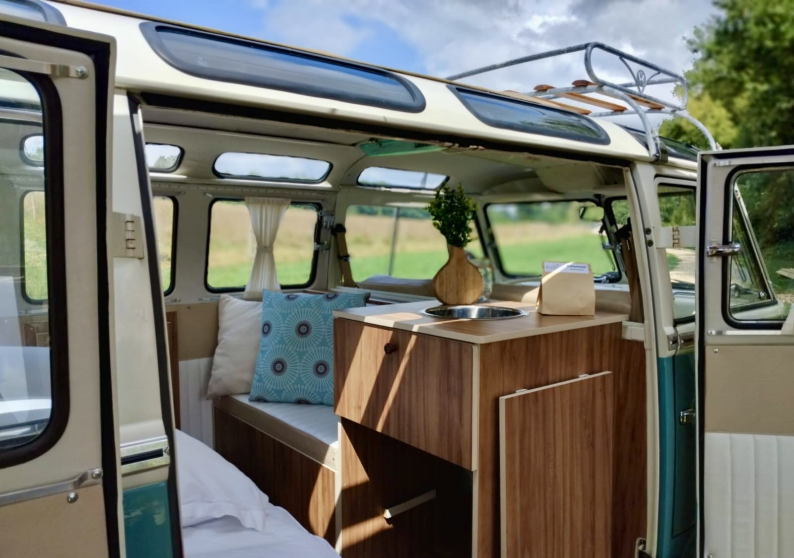 Binnenkant van de Combi Harvey-cabine met houten keuken en bed bij Domaine des Feuilles in Frankrijk.