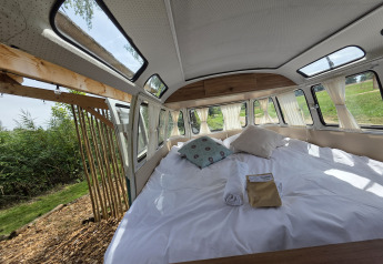 Innenansicht von Combi Harvey in Domaine des Feuilles, Frankreich, mit Bett und Blick ins Grüne.