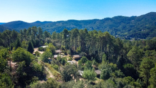 Luchtfoto van vakantiepark Bivouac nature in Occitanië, Frankrijk, omgeven door bossen en bergen.