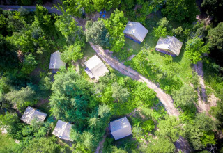 Vista aerea del parco vacanze Bivouac nature in Occitania, Francia, con bungalow immersi nel verde.
