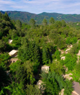 Vista aérea del parque vacacional Bivouac Nature en Occitania, Francia, rodeado de bosques y colinas verdes.