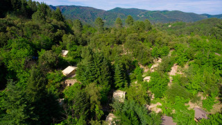 Luchtfoto van Bivouac Nature vakantiepark in Occitanië, Frankrijk, gelegen tussen groene heuvelbossen.