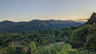 Uitzicht op groene bossen en heuvels bij zonsondergang in Bivouac nature vakantiepark in Occitanie, Frankrijk.