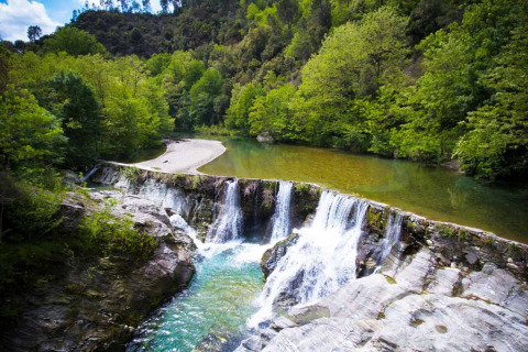 Piccola cascata e fiume limpido immersi nel verde vicino a Saint Jean du Gard, Occitania, Francia.