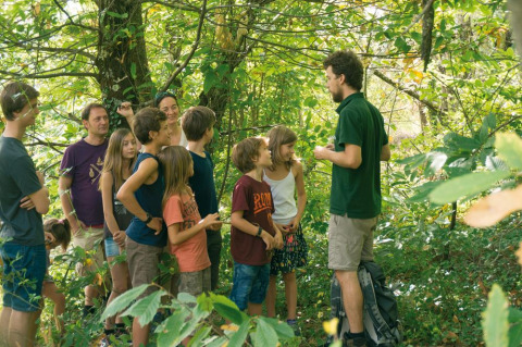 A group of children and adults on a guided nature walk at Bivouac Nature holiday park in Occitanie, France.