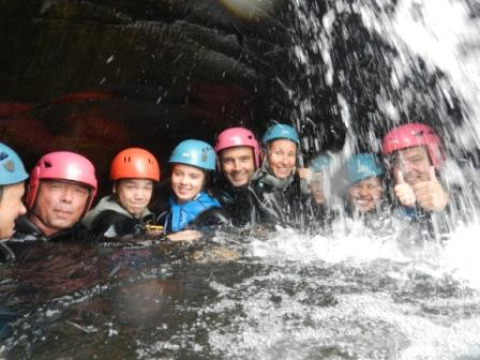 Eine Gruppe Menschen mit Helmen genießt ein Wasserabenteuer im Bivouac Nature in Okzitanien, Frankreich.