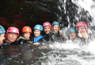 Eine Gruppe Menschen mit Helmen genießt ein Wasserabenteuer im Bivouac Nature in Okzitanien, Frankreich.