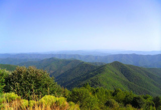 Veduta panoramica di colline verdi e cielo blu al parco vacanze Bivouac nature in Occitania, Francia.