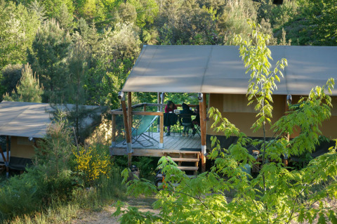 Tente safari Baroudeur au Bivouac nature en France, entourée d'arbres et de nature verdoyante.
