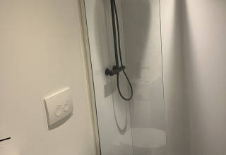 Moderne badkamer met douche, toilet en wastafel bij Solo Retreat in Reestervallei, Nederland.