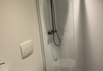 Baño moderno con ducha, inodoro y lavabo en Solo Retreat en Reestervallei, Países Bajos.