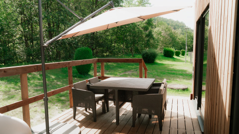 Houten terras met tuintafel, stoelen en parasol bij Eco Lodge MOBIWOOD, Camping Floreal La Roche-en-Ardenne.