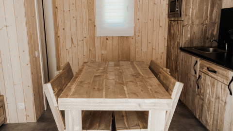 Rustieke houten eettafel en banken in de keuken van Eco Lodge MOBIWOOD, Camping Floreal La Roche-en-Ardenne.