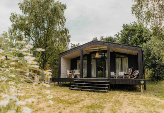 Foto van The Hills met Hottub lodge, gelegen in het groen met houten terras en buitenzitjes.