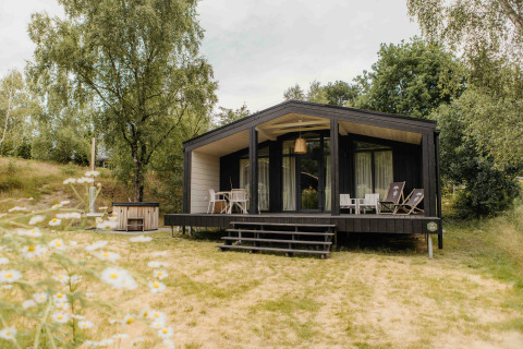 Moderne lodge The Hills met hottub bij Wilsumer Berge in Duitsland, omringd door natuur en bomen.
