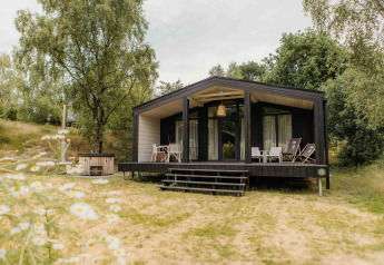 Moderne lodge The Hills met hottub bij Wilsumer Berge in Duitsland, omgeven door natuur en bomen.