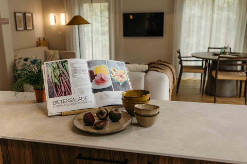 Keukenblad met kookboek, kommen en verse bieten in The Hills met Hottub lodge, Wilsumer Berge, Duitsland.