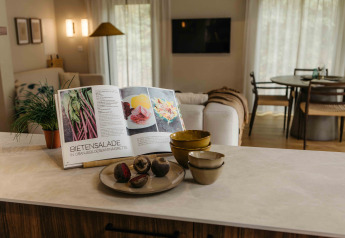 Keukenblad met kookboek, kommen en verse groenten bij The Hills met Hottub lodge, Wilsumer Berge, Duitsland.