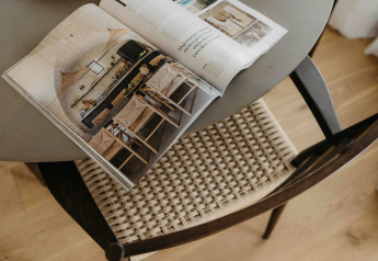 Open tijdschrift op ronde tafel met gevlochten stoel bij The Hills met Hottub, Wilsumer Berge, Duitsland.