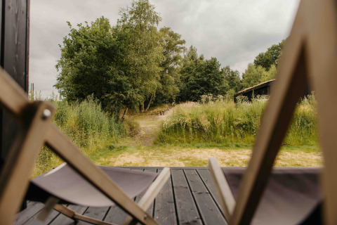 Uitzicht vanaf The Hills met Hottub, Wilsumer Berge, Duitsland, met ligstoelen en groene natuur buiten.