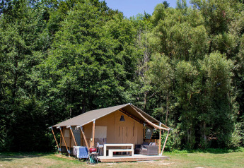 La tente safari Villatent Wood au Camping Au Clos de La Chaume en France, entourée de forêt verdoyante.
