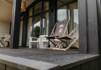 Terras bij The Hills met Hottub lodge in Wilsumer Berge, Duitsland, met strandstoelen en rustig uitzicht.