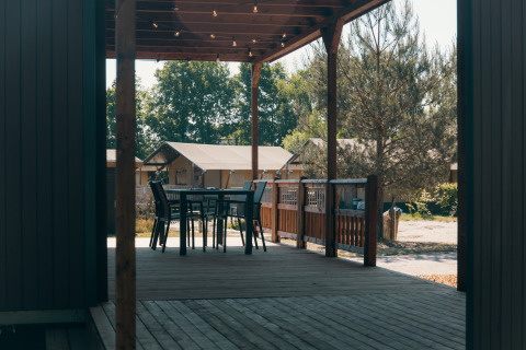 Terrasse en bois avec table et chaises aux Tiny Wander Lodges au Holiday Park Sallandshoeve, Pays-Bas.