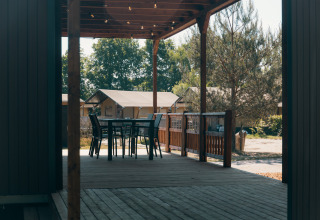 Terrasse en bois avec table et chaises aux Tiny Wander Lodges au Holiday Park Sallandshoeve, Pays-Bas.