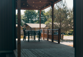 Terrasse en bois avec table et chaises aux Tiny Wander Lodges au Holiday Park Sallandshoeve, Pays-Bas.
