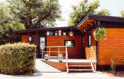 Bungalow in legno al Camping Liefrange, parco vacanze a Wiltz, Lussemburgo, con decorazioni floreali.