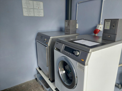 Coin-operated washing machines and dryer at Camping Liefrange holiday park in Wiltz, Luxembourg.