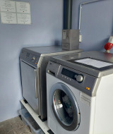 Münzbetriebene Waschmaschinen und Trockner im Camping Liefrange Ferienpark in Wiltz, Luxemburg.