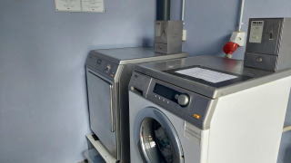 Münzbetriebene Waschmaschinen und Trockner im Camping Liefrange Ferienpark in Wiltz, Luxemburg.