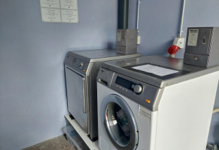 Coin-operated washing machines and dryer at Camping Liefrange holiday park in Wiltz, Luxembourg.