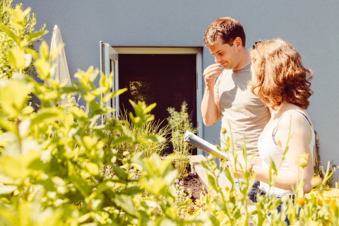 Dos personas disfrutan del jardín en su casa de vacaciones en Camping Liefrange, Wiltz, Luxemburgo, entre plantas.