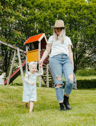 Mutter und Kind spielen auf der Wiese bei Spielplatz und Rutsche im Camping Liefrange, Wiltz, Luxemburg.