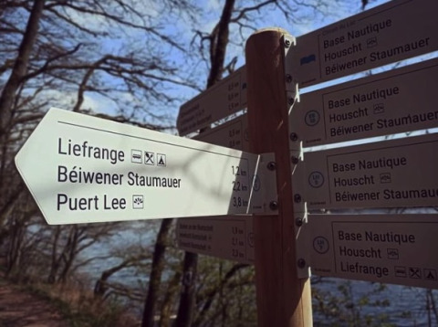 Signpost at Camping Liefrange holiday park in Wiltz, Luxembourg, indicating nearby tourist destinations.