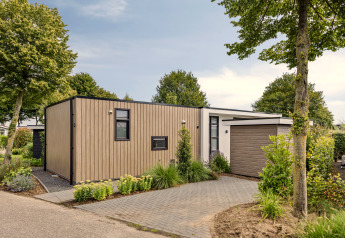 Lodge moderne Module Special 4 personnes, bardage bois, grande allée et espaces verts à l’avant.