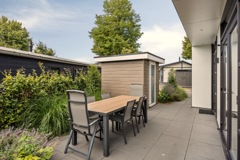Terrasse extérieure avec table et six chaises près du lodge Module Special 4 au Recreatiepark het Esmeer.