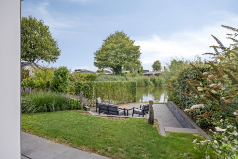 View from a lodge at Recreatiepark het Esmeer in the Netherlands with outdoor seating and canal scenery.