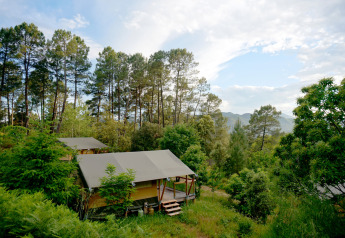 Das Safari-Zelt Baroudeur Tent bei Bivouac nature in Frankreich, umgeben von Wald und Bergen bei klarem Himmel