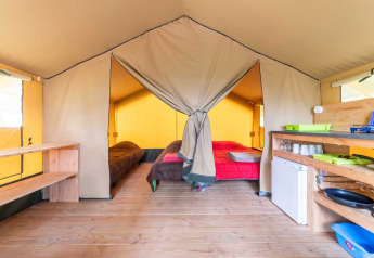 Innenansicht vom Safari Baroudeur Zelt im Bivouac Nature in Frankreich mit Betten und Küchenecke.
