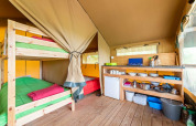 Interno della tenda safari Baroudeur con letti a castello e cucina a Bivouac Nature, Francia.