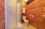 Bagno in una tenda safari Canadienne con rivestimento in legno, doccia e WC a Bivouac Nature in Francia.