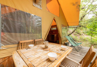 Houten buitentafel met stoelen bij de Cabane safaritent in Bivouac nature, Frankrijk.