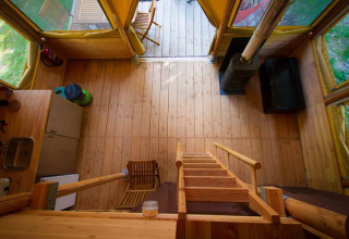 Interieur van de Cabane safaritent bij Bivouac nature in Frankrijk, met houten vloer en keukenblok.