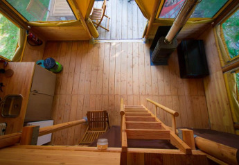 Interieur van de Cabane safaritent bij Bivouac nature in Frankrijk, met houten vloer en keukenblok.