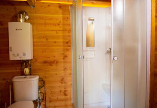 Houten badkamer met douche en toilet in een safaritent genaamd Cabane bij Bivouac nature in Frankrijk.